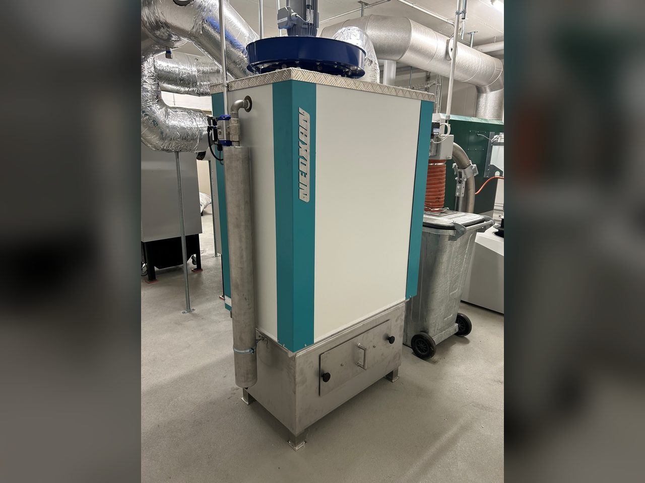 Neoxan Kompaktanlage mit Gewebefilter und Ventilator in einer Industriehalle